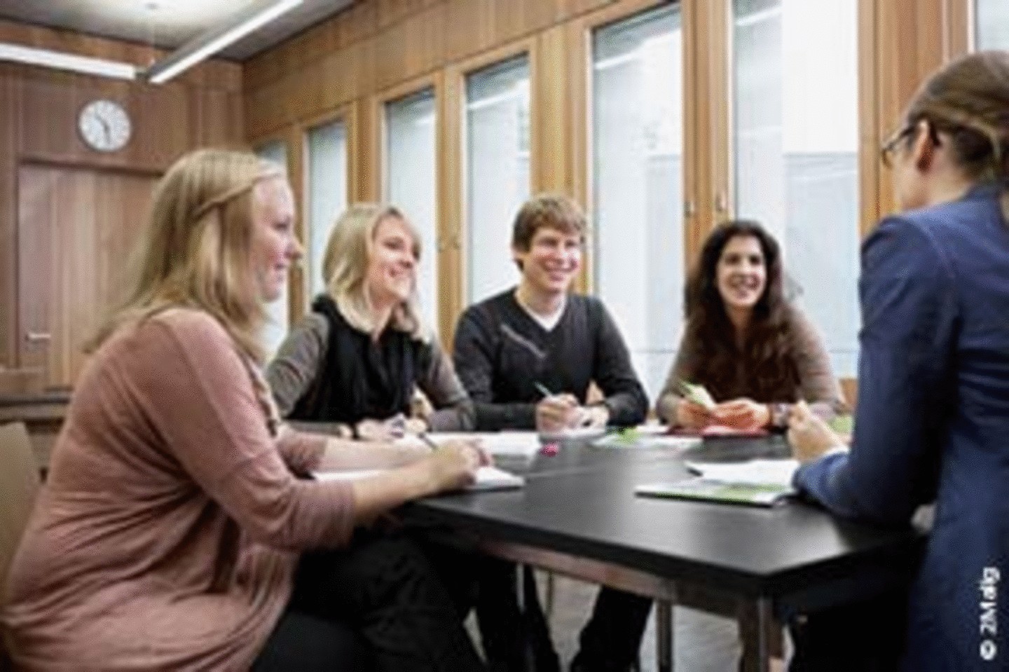 Gruppe von Studierenden sitzt einer Beraterin des WiSo Career Service an einem Tisch gegenüber.
