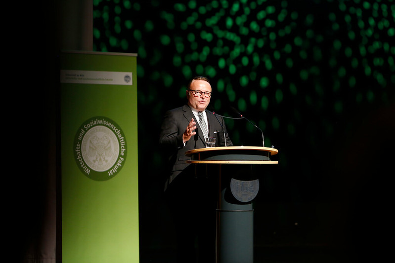 Alumnus speaking on stage during graduation ceremony