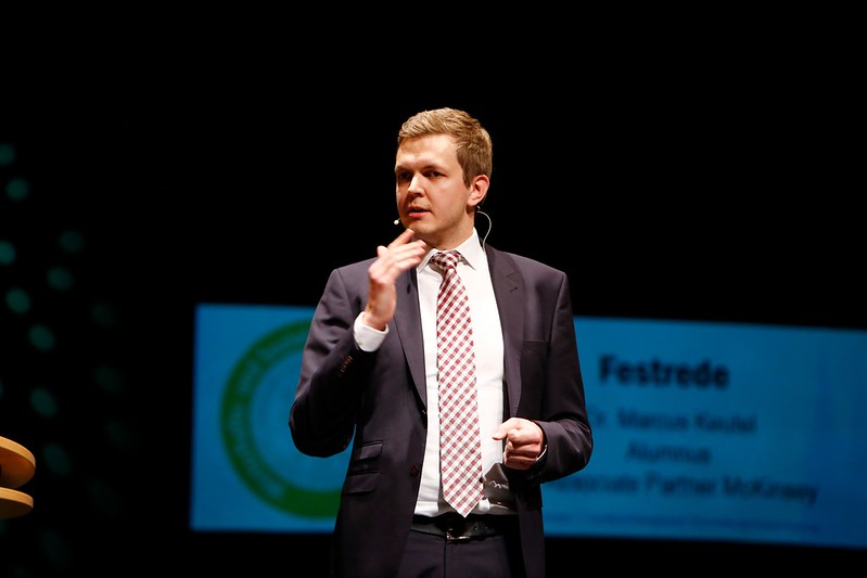 Alumnus speaking on stage during graduation ceremony