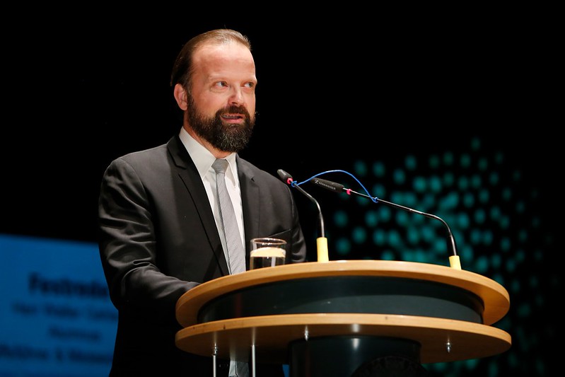 Alumnus speaking on stage during graduation ceremony