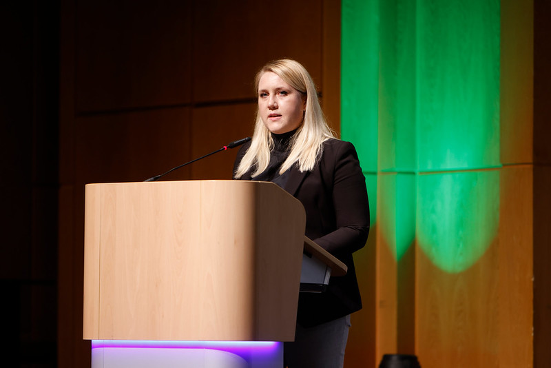 Alumna speaking on stage during graduation ceremony