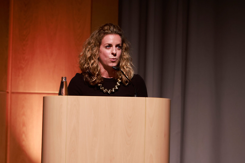 Alumna speaking on stage during graduation ceremony