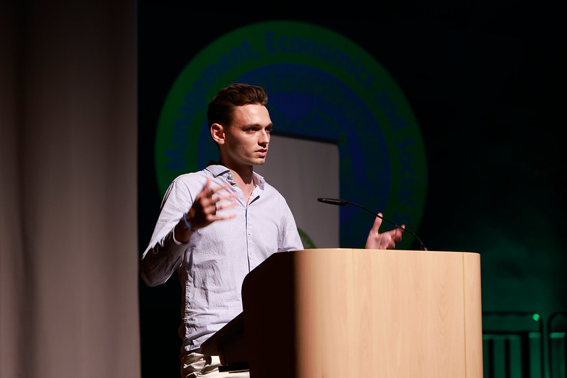 Alumnus speaking on stage during graduation ceremony