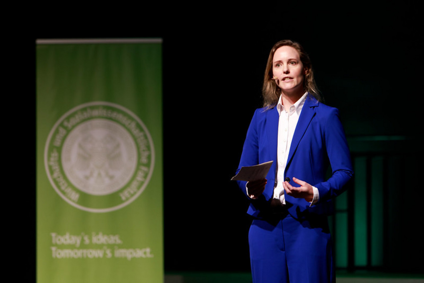 Alumna speaking on stage during graduation ceremony