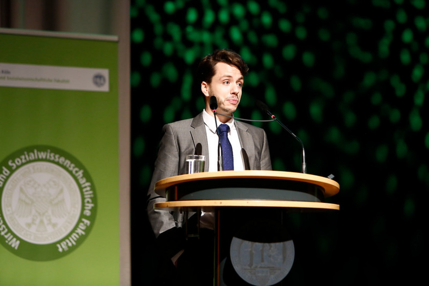 Alumnus speaking on stage during graduation ceremony