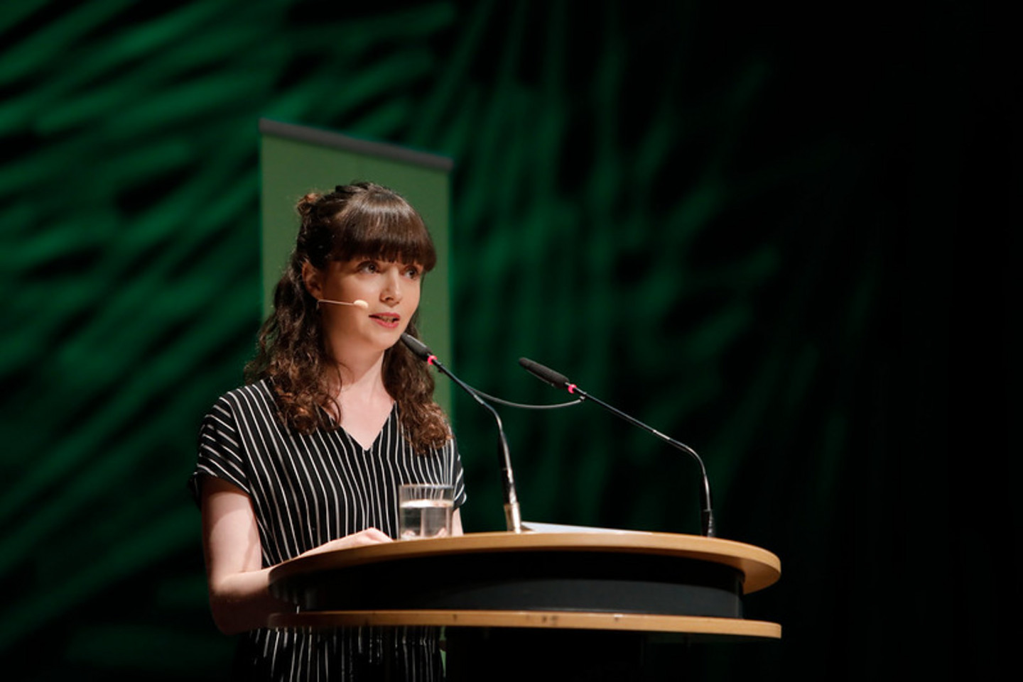 Alumna speaking on stage during graduation ceremony