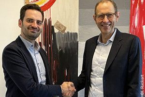 Handshake von Prof. Dr. Johannes Wohlfart und WiSo-Dekan Prof. Ulrich Thonemann, Ph.D. vor einem abstrakten Gemälde im Stil des Nouveau Realisme