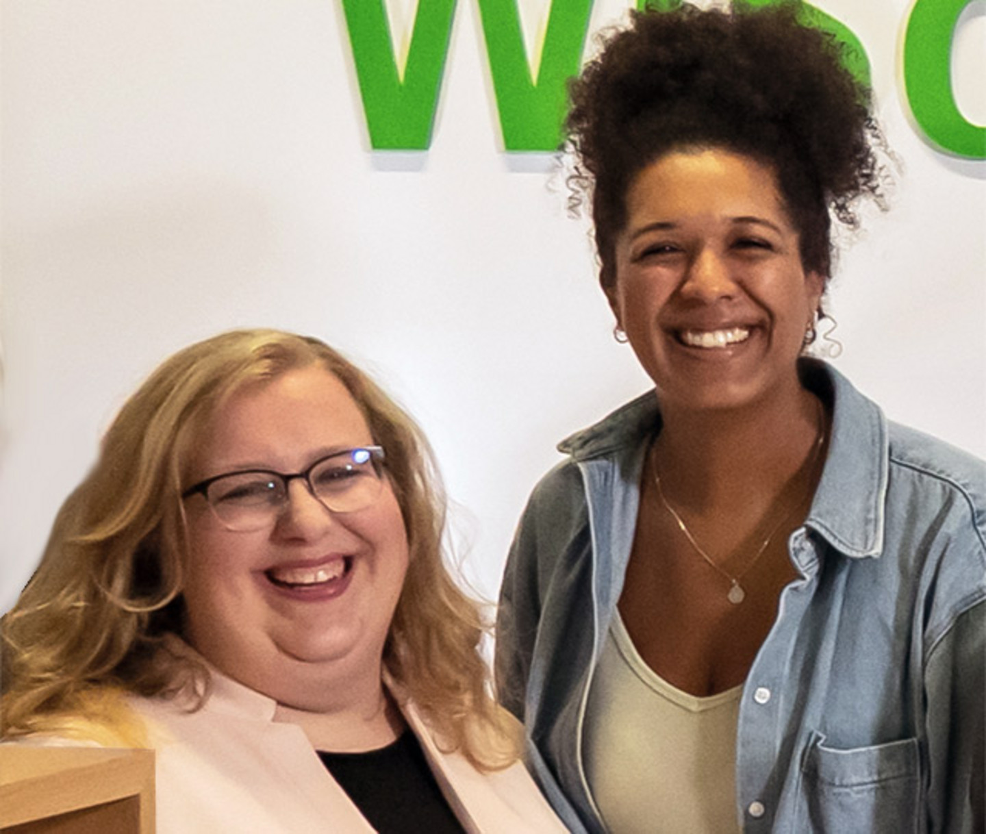 Inken Host and Vanessa Vemba smiling behind the WiSSPo reception desk