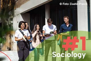 Students from the University of Cologne in front of the glas front of the WiSo Extension building, with text: #1 Sociology'. Photo by Dustin Preick.