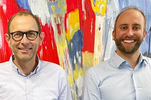 Profes. Ulrich Thonemann und Sebastian Siegloch vor einem abstrakten bunten Gemälde