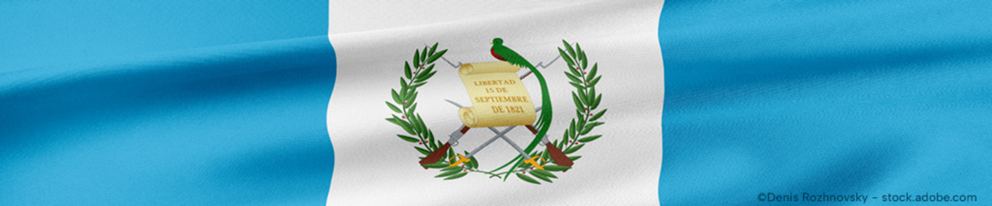 Detail of the Guatemalan flag with three vertical bars in sky blue, white, sky blue and the national coat of arms on the centre white bar