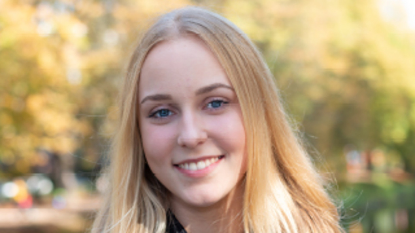 Nahaufnahme von WiSo-Studentin Corinna vor herbstlichen Bäumen - Text: "Today's Ideas. Tomorrow's Impact. My idea of life is to look back one day, have no regrets and see positive results of my work/doing in someone else's life."."