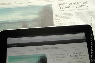 Ein tablet liegt auf einer Zeitungsseite mit gleichem Inhalt