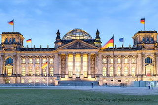 The illuminated and flagged Reichstag in Berlin