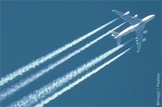 Aircraft with wide contrails in the sky 