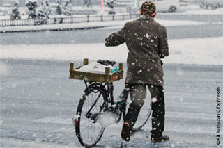 Person mit Fahrrad im Schnee
